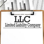 Paper with LLC on chart with calculator,pen and magnifier