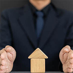 Hands of businessmen or homeowners that are blocking Domino's fall from home.