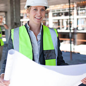 Construction worker with vest and hard hat holding a blue print