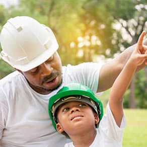 Cheerful boy and father playing in park