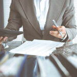 Bookkeeper woman or financial inspector making report, calculating or checking balance, close-up. Business, audit or tax concepts.