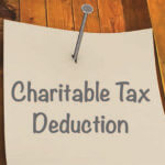 Yellow piece of paper reading "Charitable donation" nailed to a piece of wood