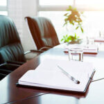 Notebook with pen in meeting room.