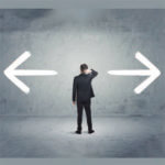 Silhouette of man standing pondering what to do with arrows pointing in each direction