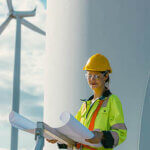 female engineer working outdoor with safety at wind turbines