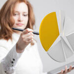Woman painting a white pie chart wedge orange