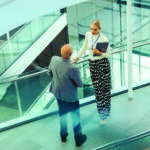 Man and woman talking in hallway of office building