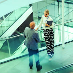 Man and woman talking in hallway of office building