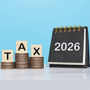 2026 desk calendar, Wooden blocks with the word TAX and stack of coins